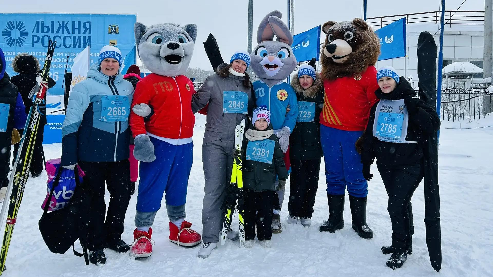 Сотрудники и дети детского сада стоят с лыжами для участия в массовом забеге Лыжня России